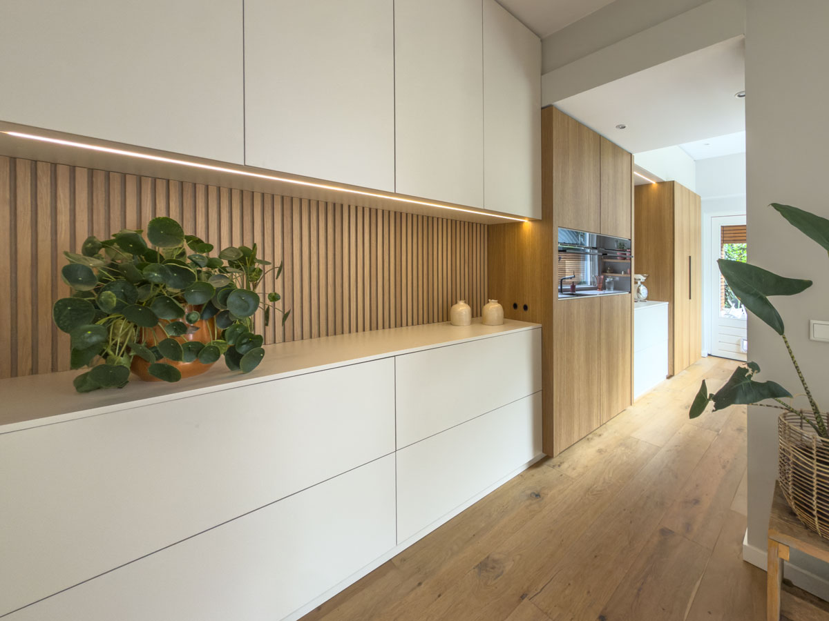 Ontwerp van een keuken op maat met beige deurtjes en houten latjes met ledstrips