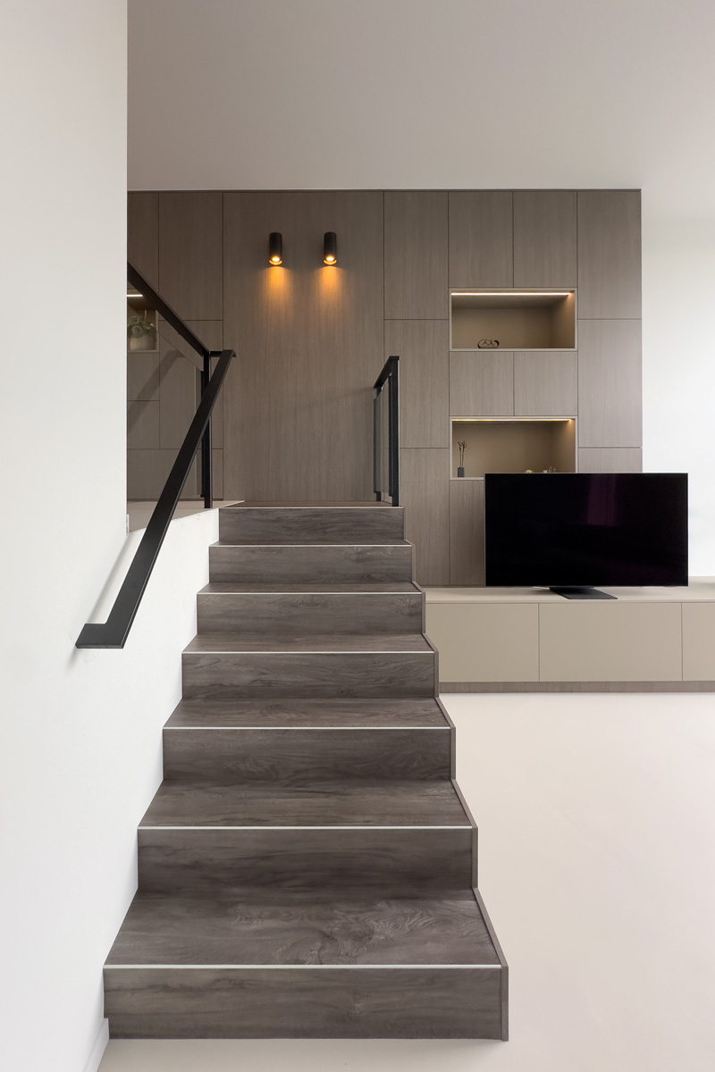 Maatwerkkast met trap, tv-meubel en ledverlichting in split-level woning