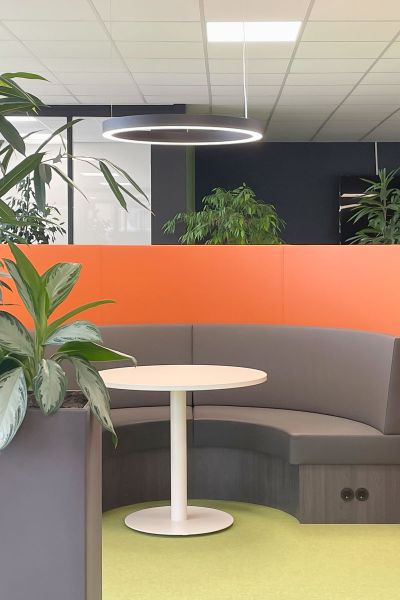 Ronde overlegplek met planten en oranje achterwand in kantoor EAGE, Bunnik.