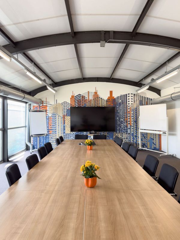 Grote vergaderzaal van het Condor-kantoor in Amersfoort met lange vergadertafel, stalen spantconstructie en skyline visual.