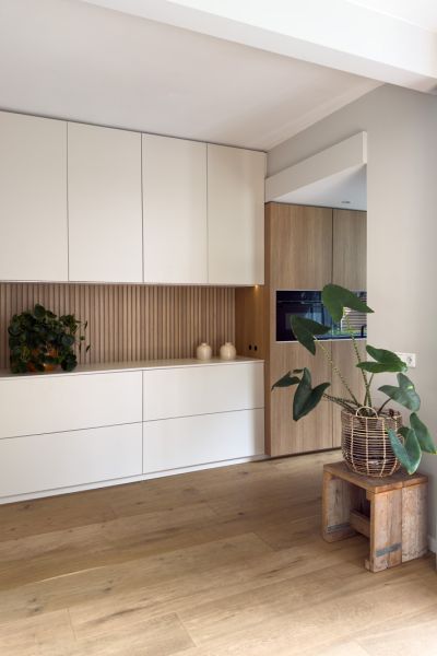 Keuken op maat in Japandi stijl met houten latjes en wandkast met ovens
